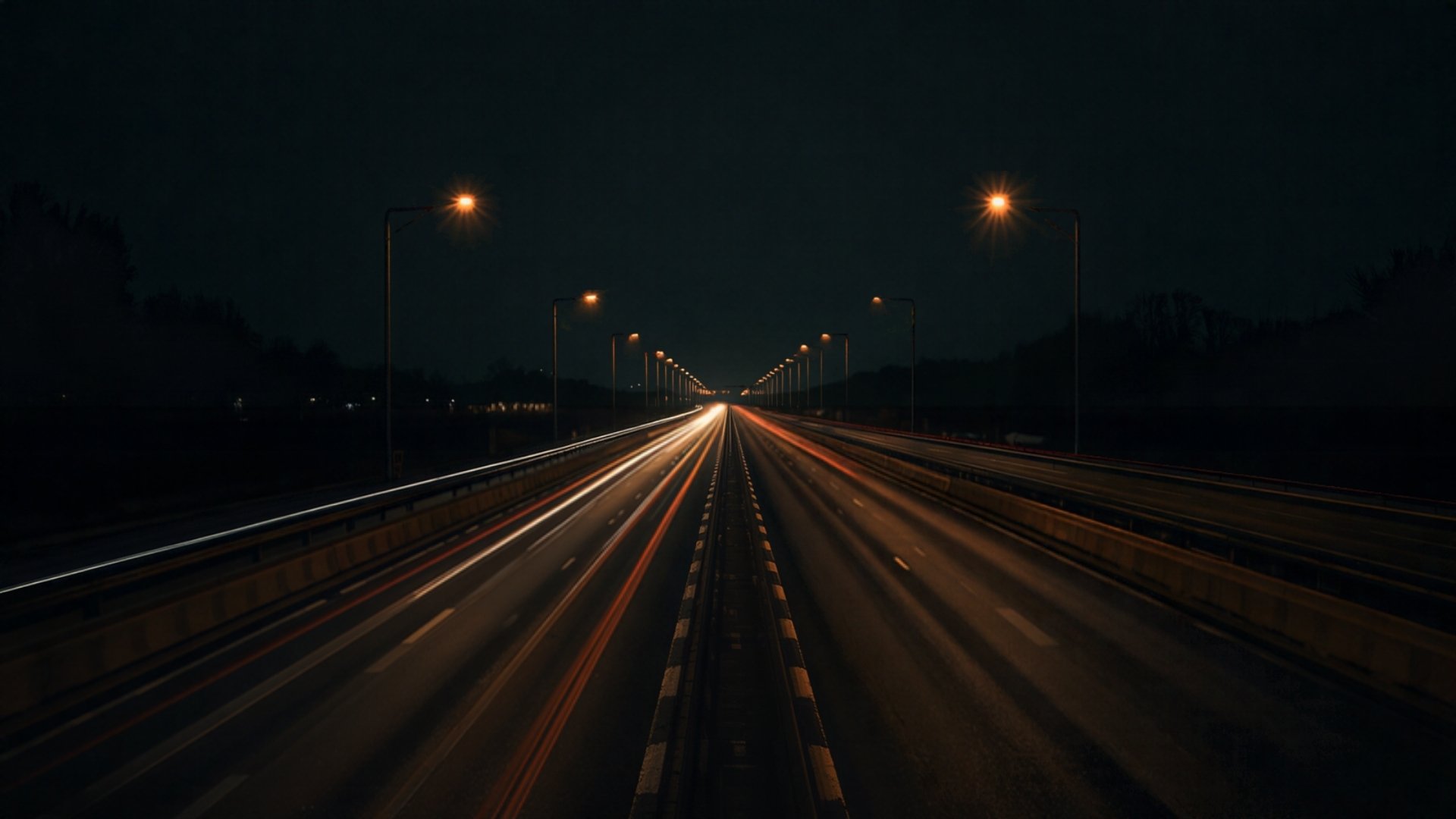 Traînées lumineuses sur une autoroute française éclairée à l’ambre, la nuit